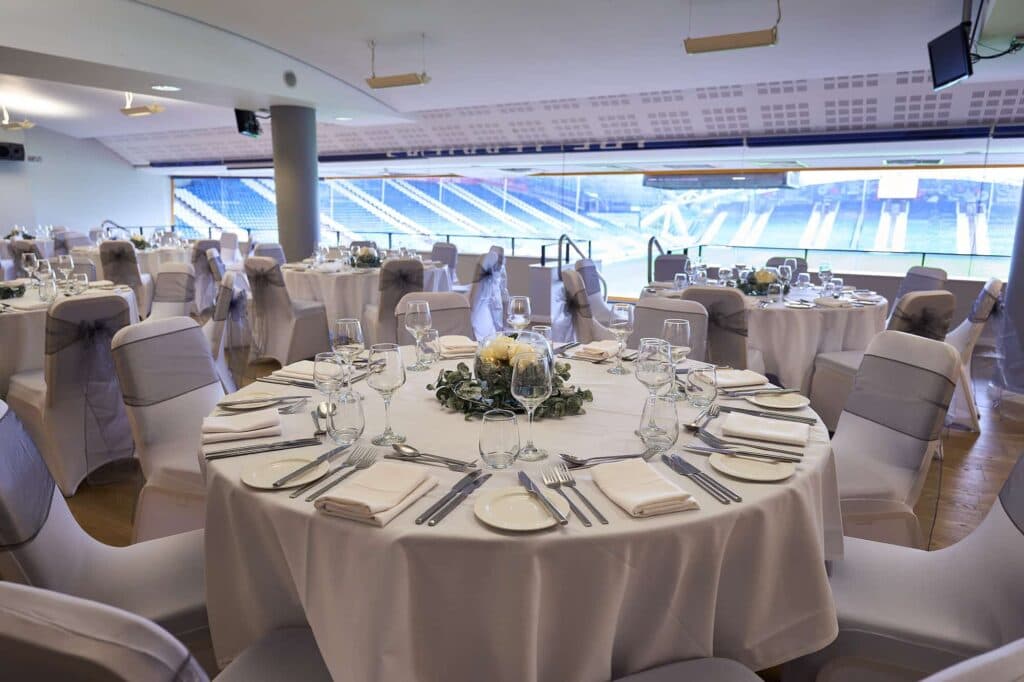 Dressed banqueting tables in a stadium function room overlooking the pitch at Accu Stadium.