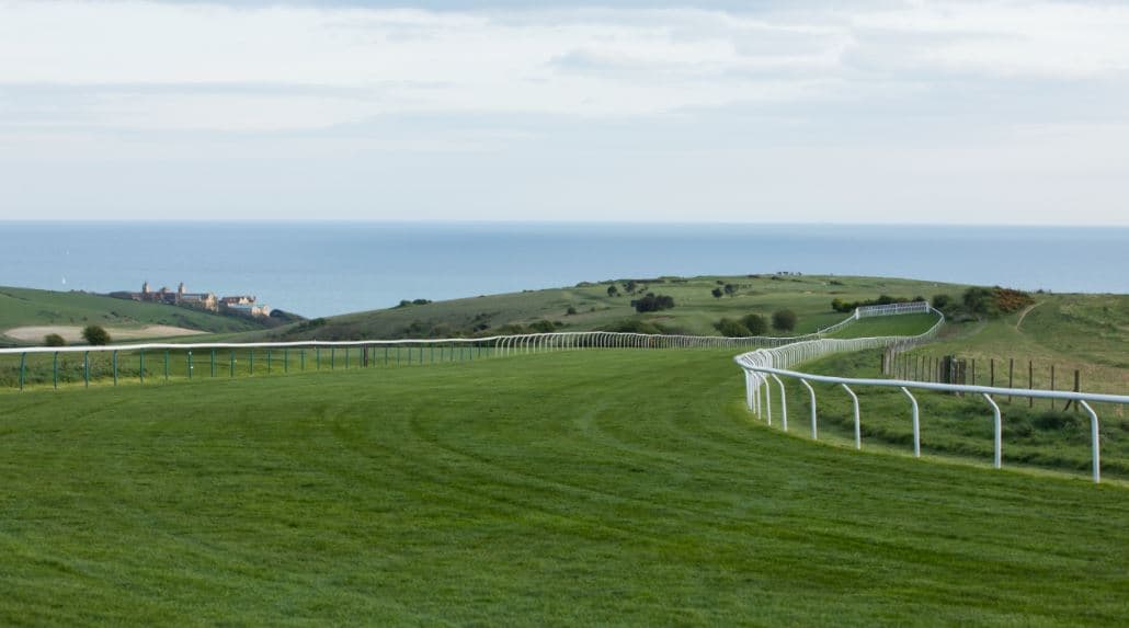 The grass racecourse at Brighton with rolling hills and sea views beyond.