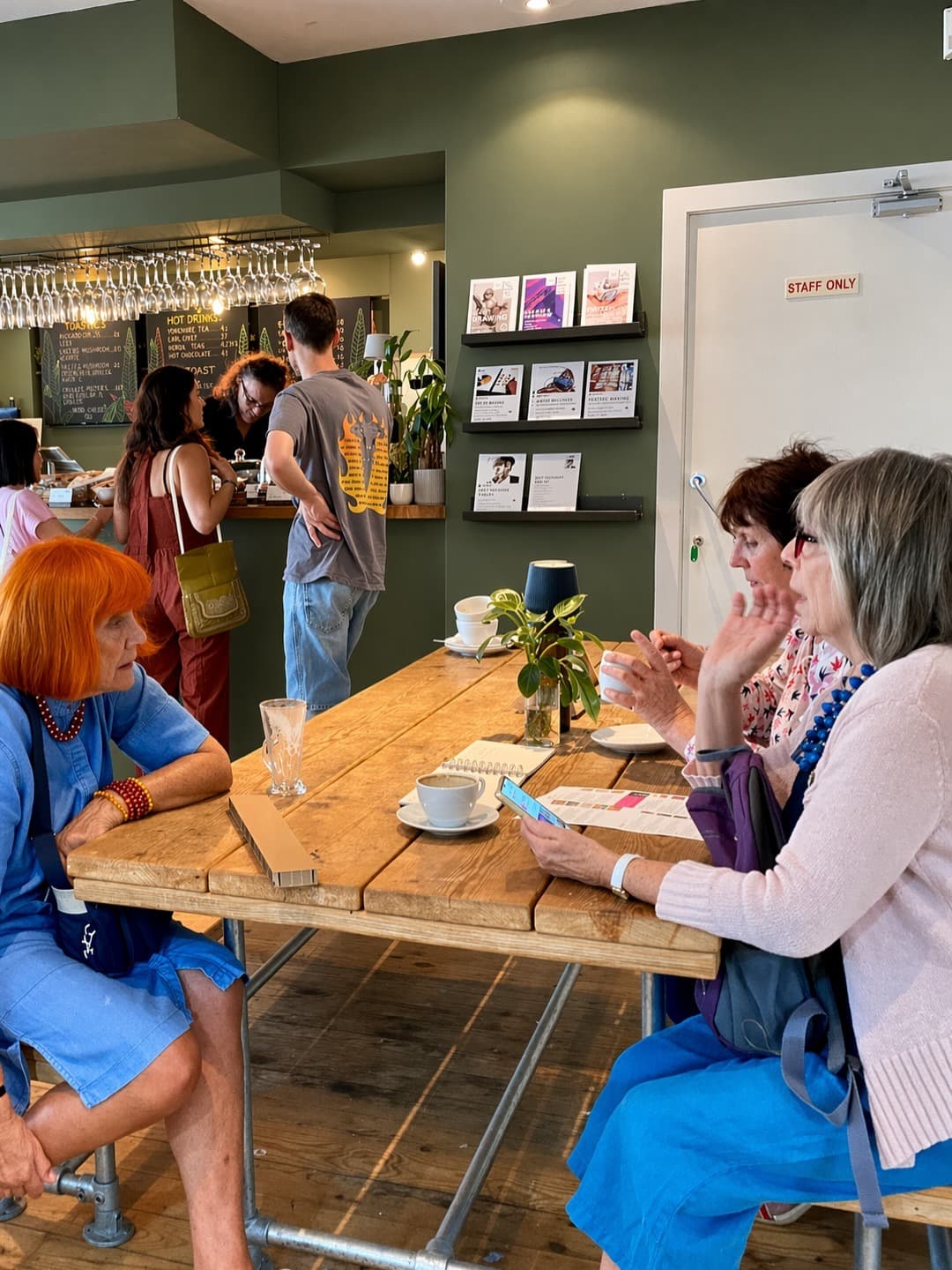 Guests seated at a rustic wooden table in the café at Chapel Allerton Arts Centre.