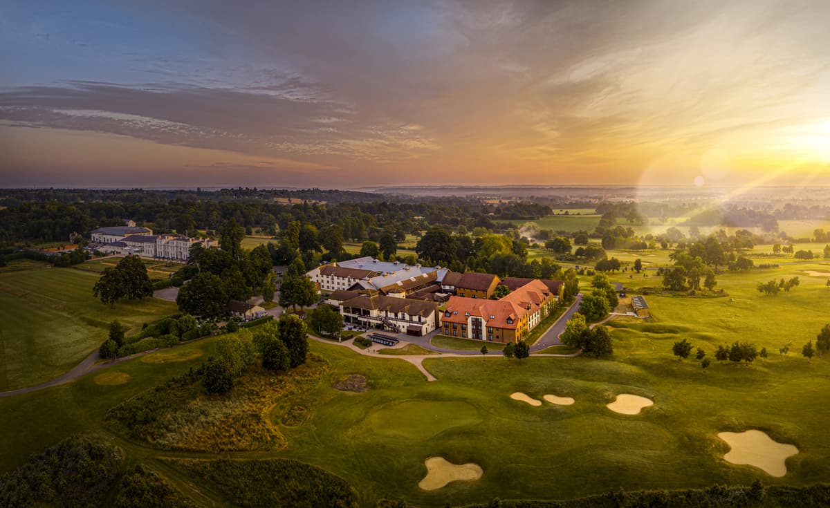 Aerial view of De Vere Wokefield Estate hotel and golf course at sunset.