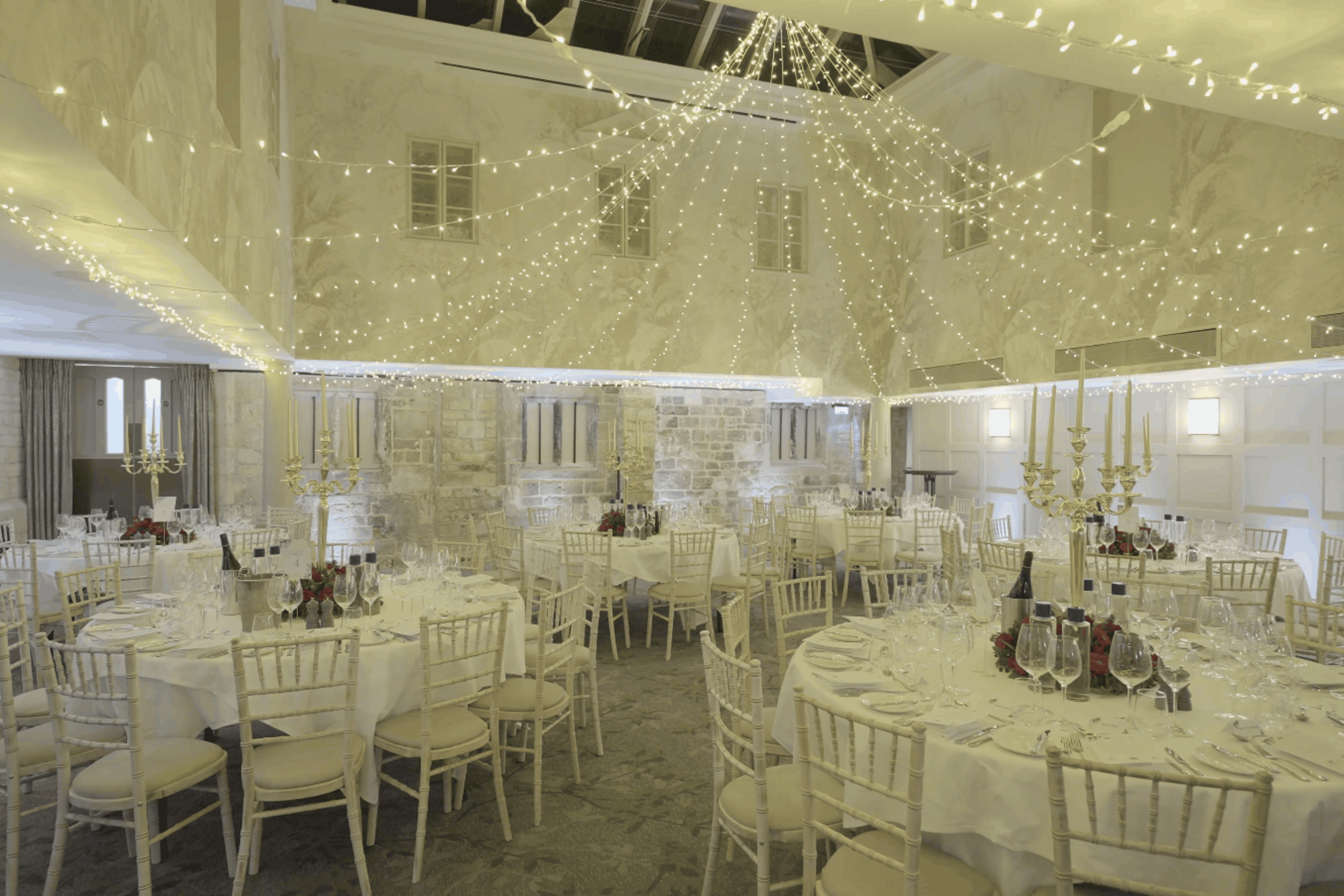 Banqueting room at Ellenborough Park dressed with fairy lights and round tables
