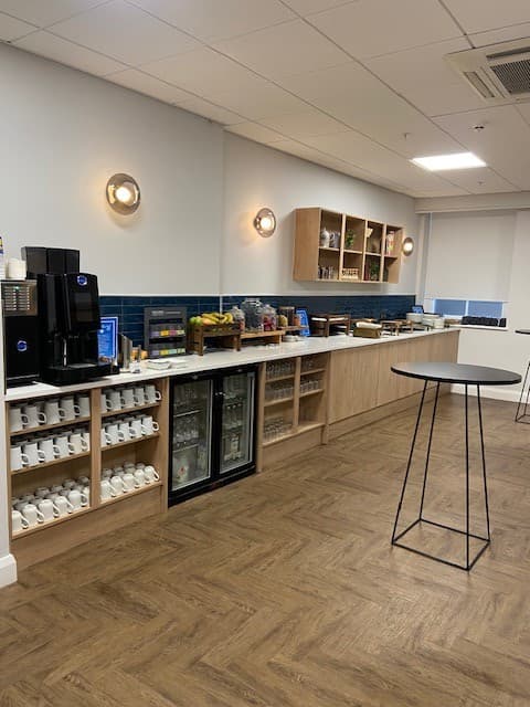 Refreshment station with coffee machine, chilled drinks fridges and white mugs at Hilton Nottingham.