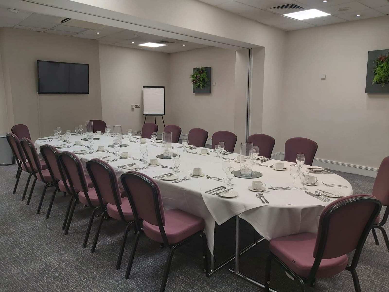 Private dining room at Hilton Nottingham with oval table set for a formal meal.