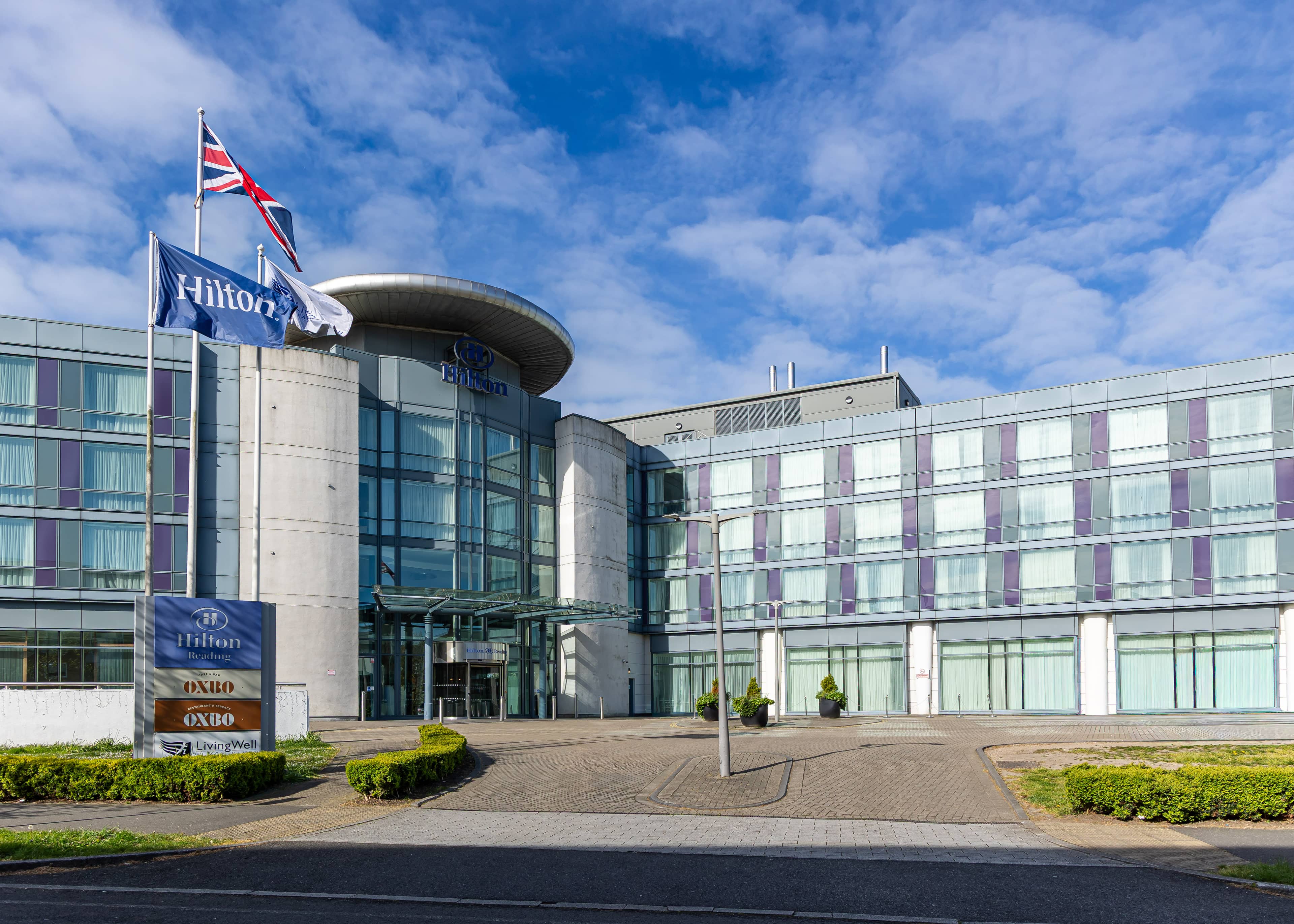 Exterior of Hilton Reading hotel with Union Jack and Hilton flags flying above the entrance.