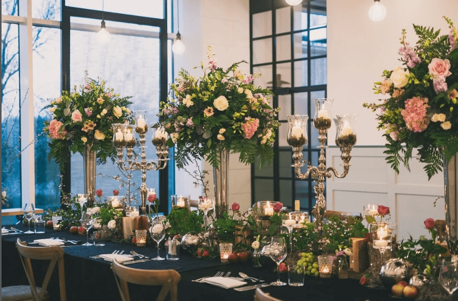Decorated top table with tall floral centrepieces, candelabras and candlelit glassware