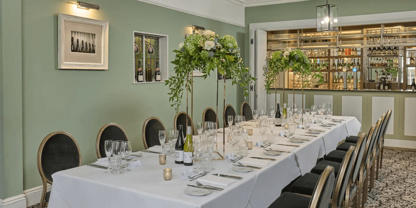 Private dining room at Hotel du Vin Brighton with long white-clothed table and tall floral centrepieces.