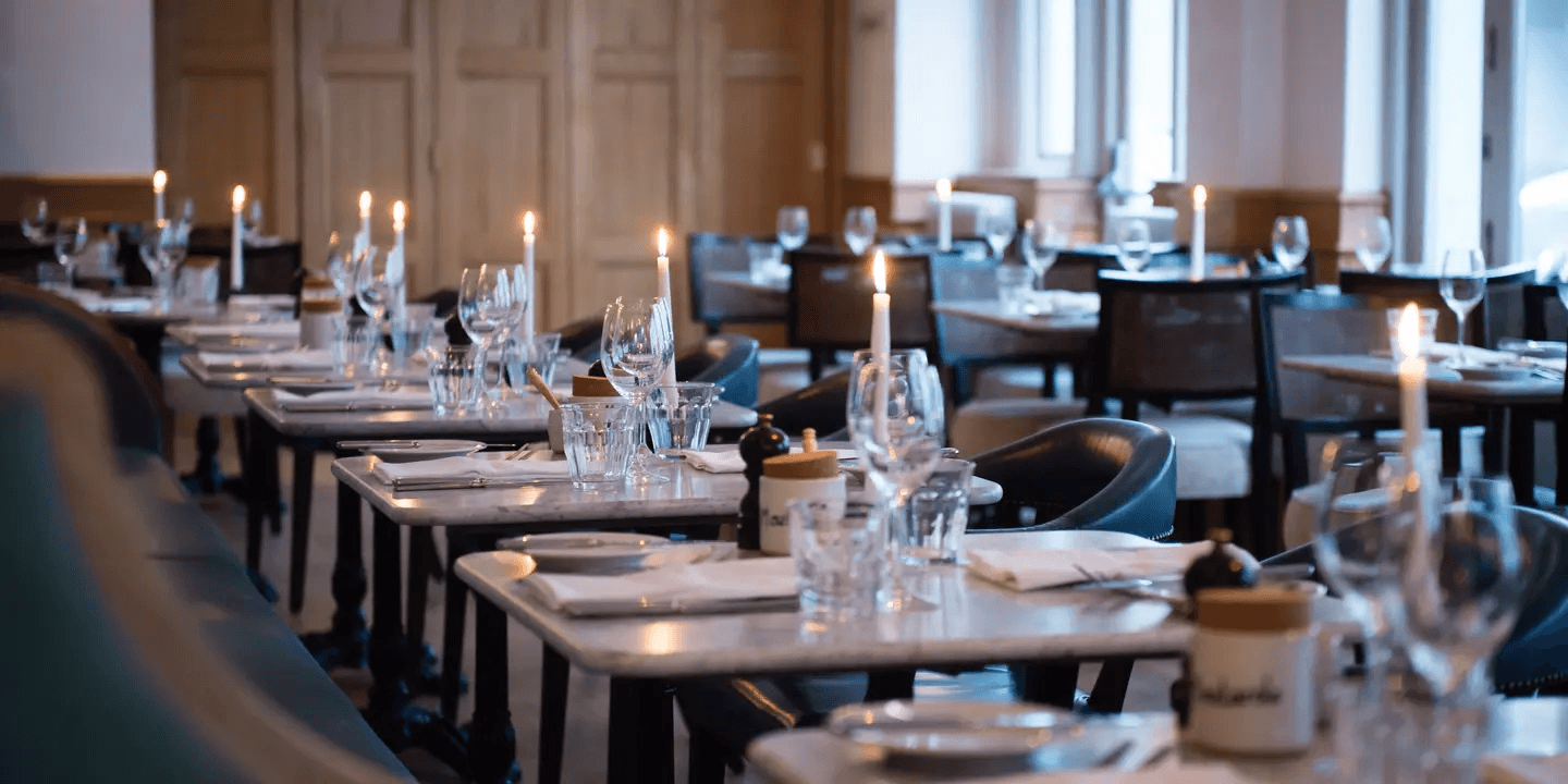 Candlelit dining room at Hotel du Vin Brighton with marble tables and wine glasses
