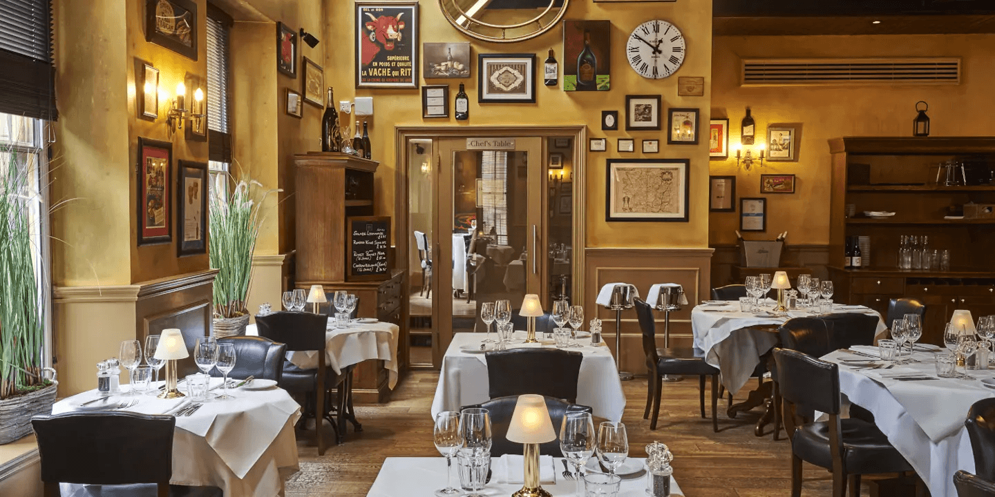 The restaurant interior at Hotel du Vin Edinburgh with white-clothed tables and French vintage posters.