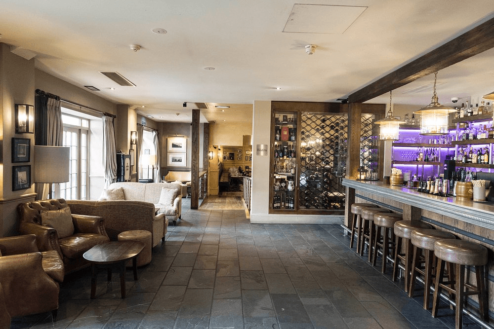 The bar and lounge area at Hotel du Vin Poole with leather seating and backlit shelves.