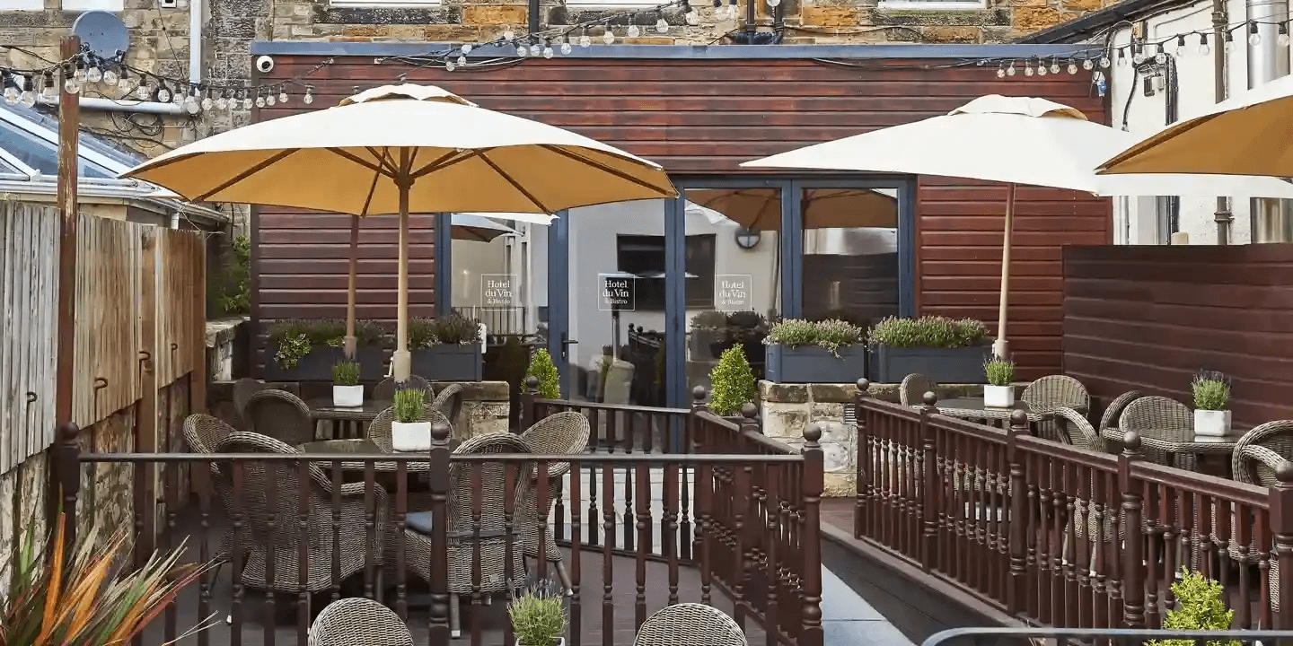 Outdoor terrace at Hotel du Vin St Andrews with rattan chairs and parasols.