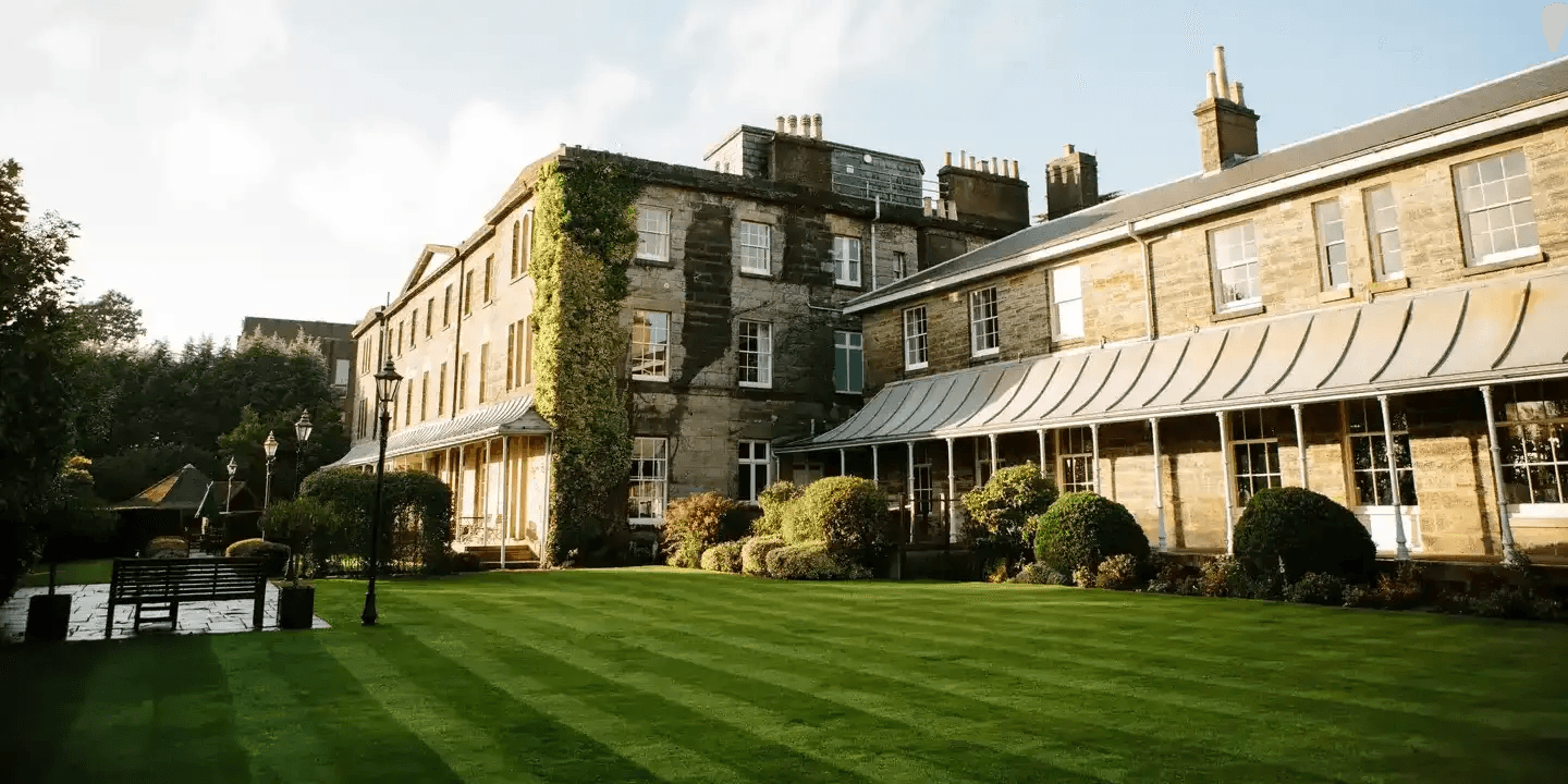 The sandstone exterior and striped lawn gardens of Hotel du Vin Tunbridge Wells
