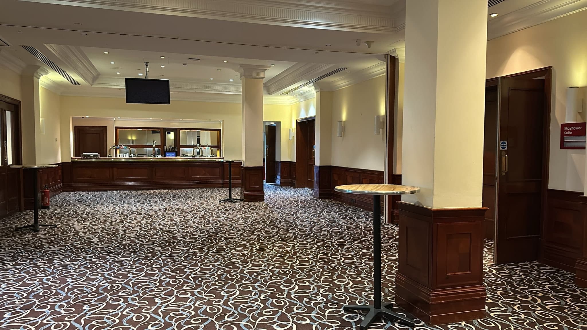 Empty foyer area at Leonardo Royal Grand Harbour Southampton with bar and patterned carpet.
