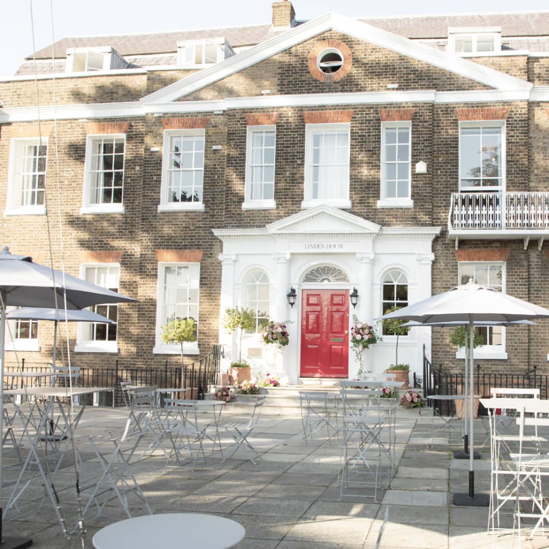 The Georgian brick exterior of Linden House with bistro tables on the terrace.