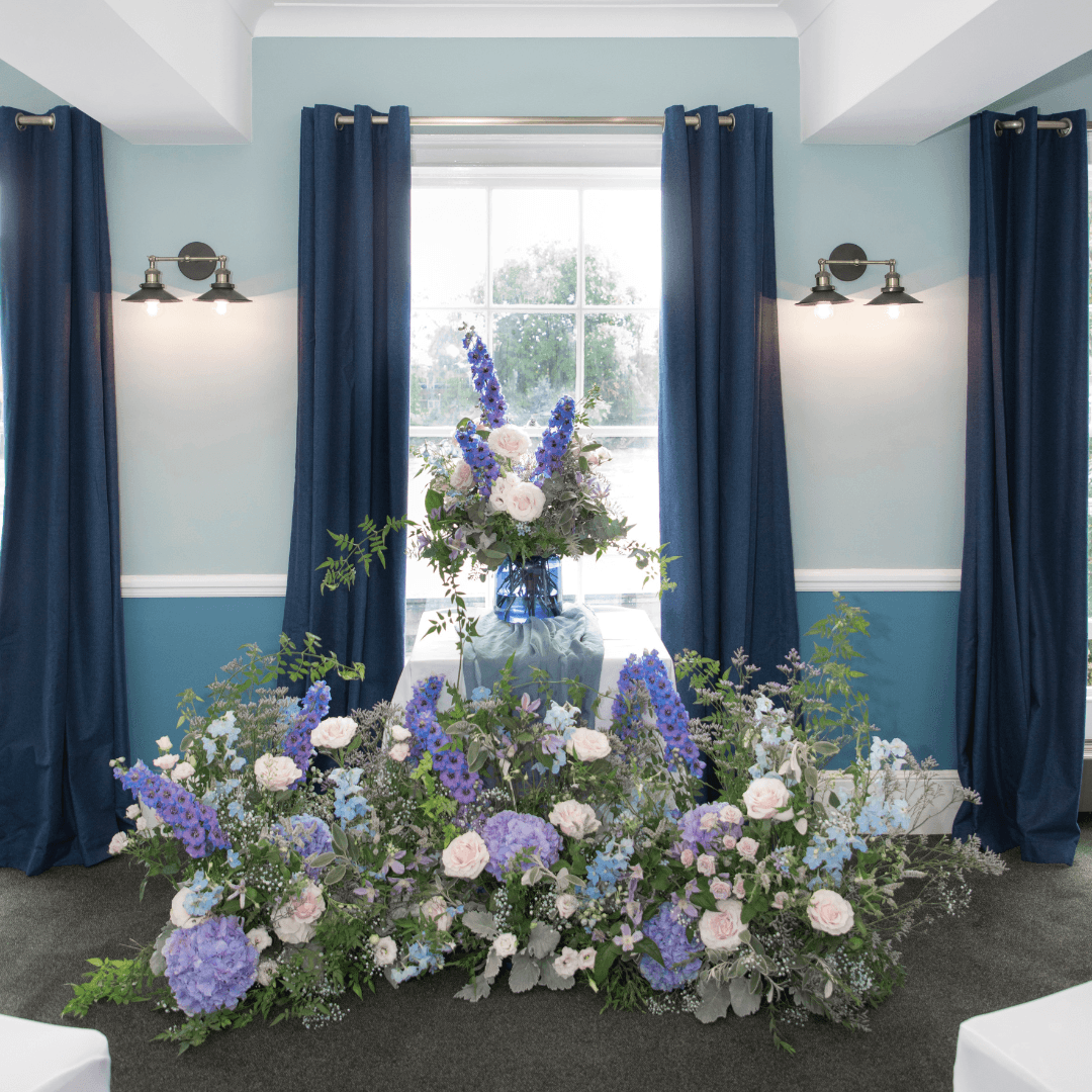 Ceremony room at Linden House Riverside decorated with blue and pink floral arrangements.