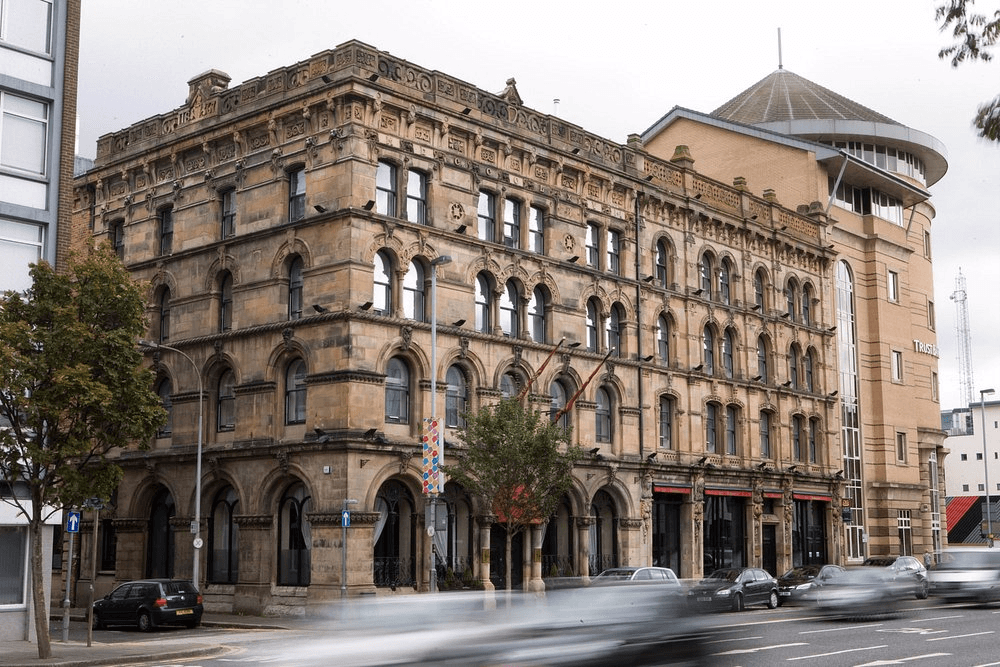 Victorian sandstone exterior of Malmaison Belfast on a city centre street corner.