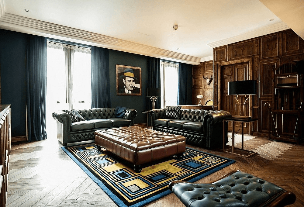 Dark leather Chesterfield sofas and wood panelling in a hotel suite lounge