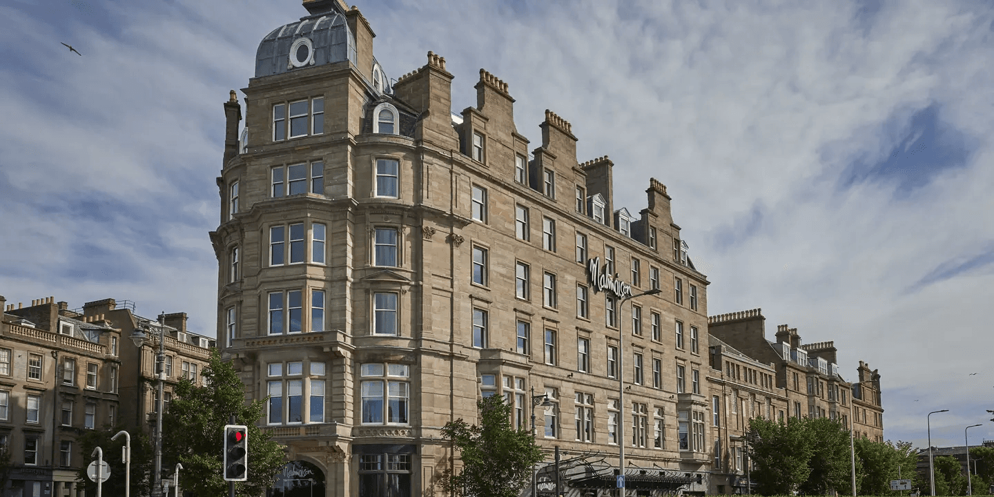 Exterior of Malmaison Dundee, a grand sandstone Victorian hotel on a city corner.