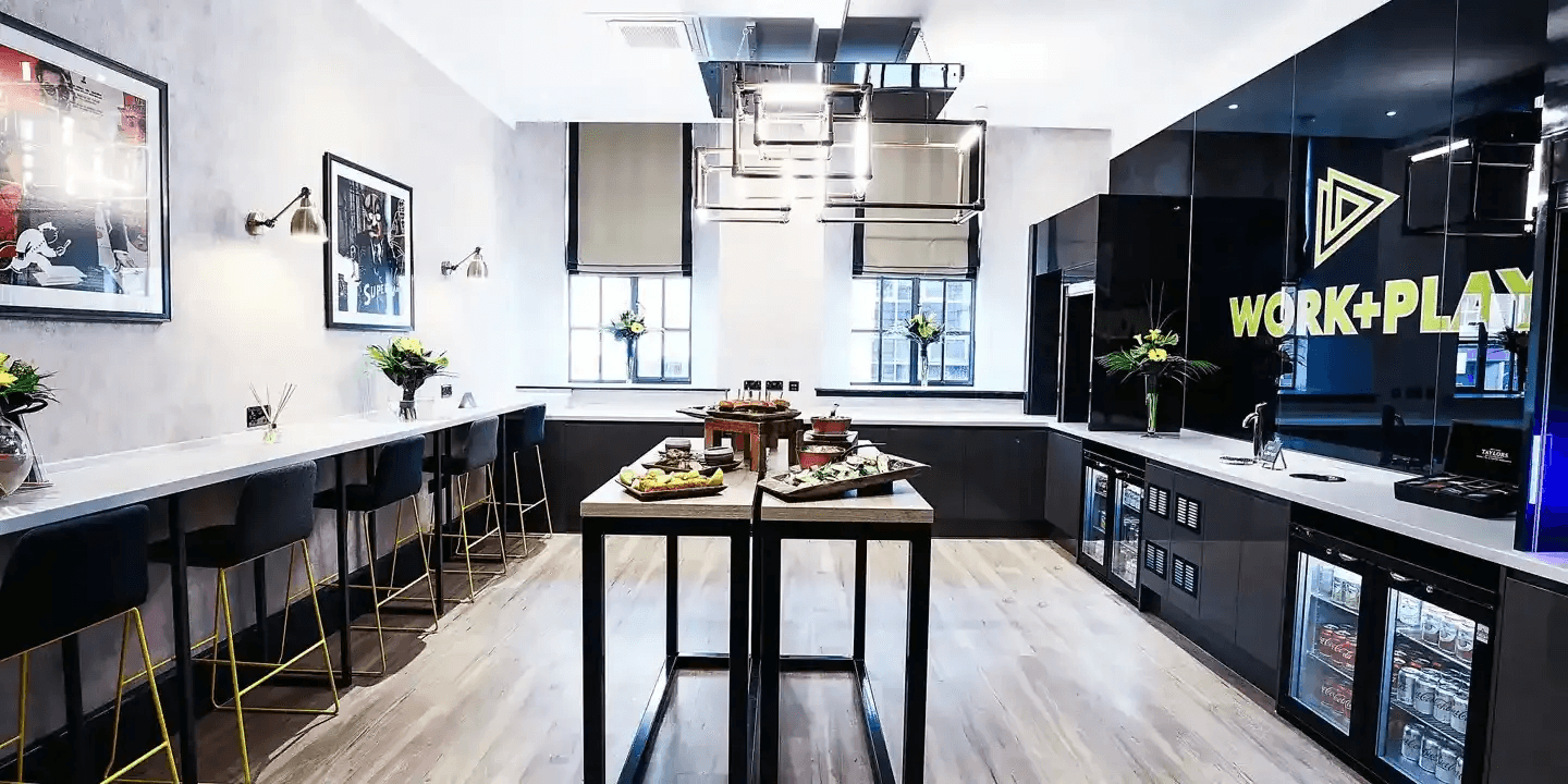 Stylish breakout kitchen area with bar stools, buffet food and chilled drinks fridges.