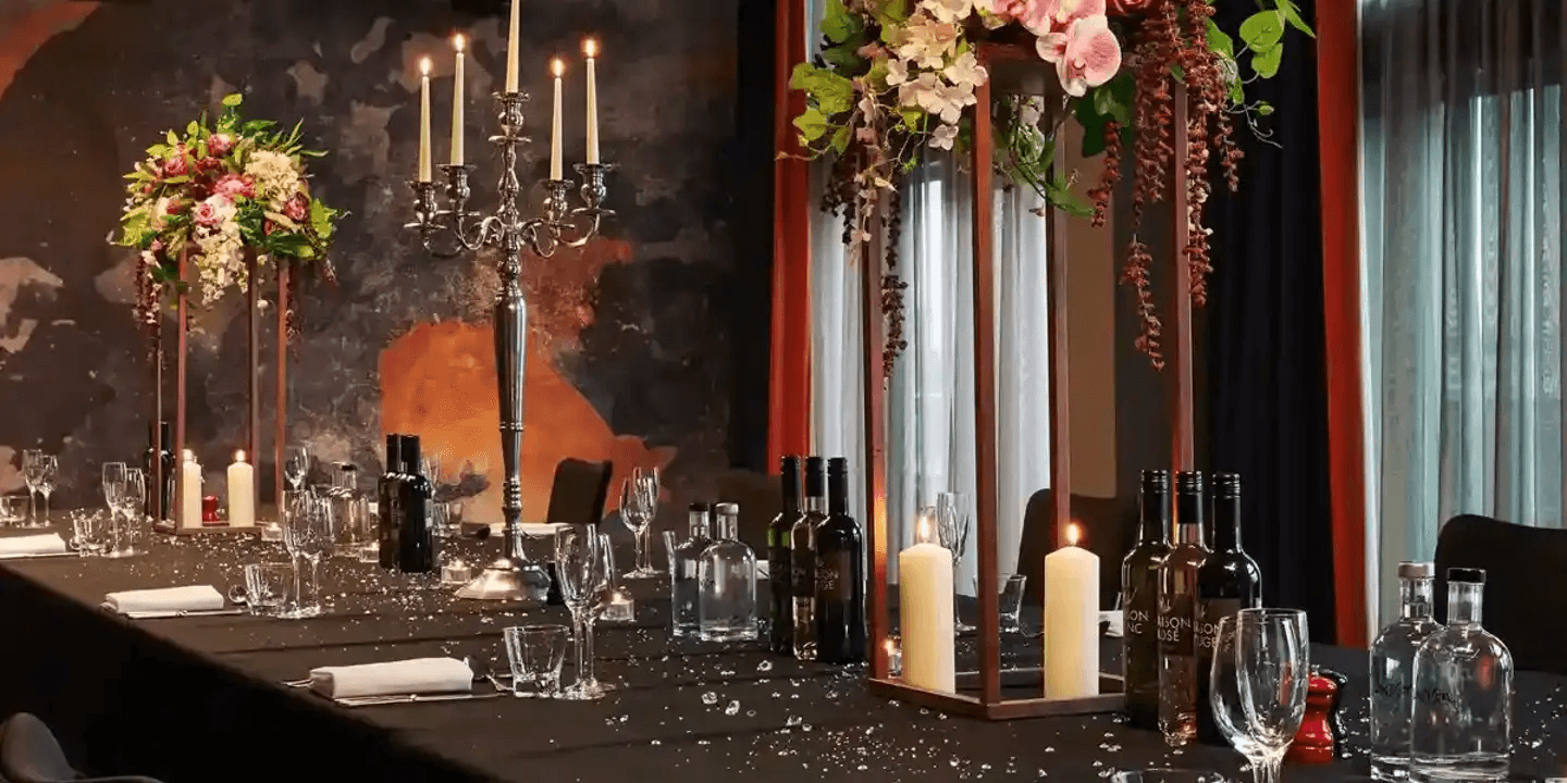 Private dining room with candelabra, pillar candles, floral arrangements and wine bottles.