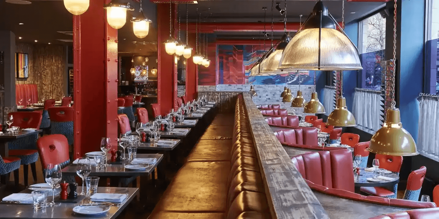 Restaurant interior at Malmaison Manchester with red leather chairs and pendant lighting.