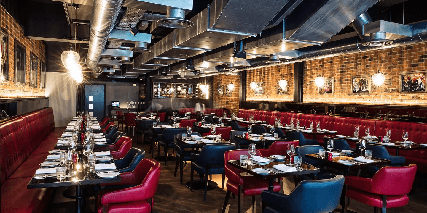 Restaurant dining room at Malmaison Reading with red leather banquettes and industrial ceiling details.