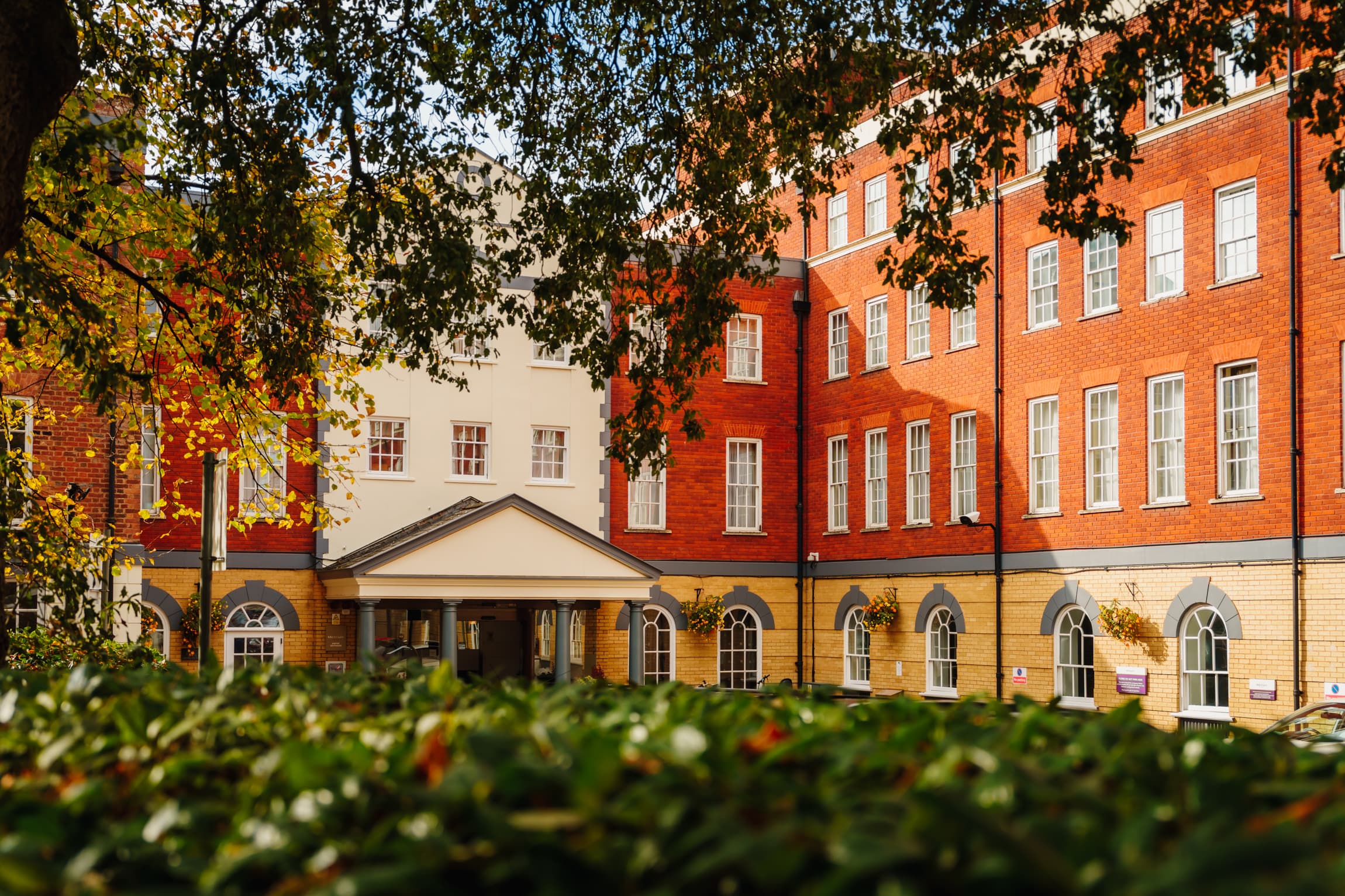 Exterior of Mercure Exeter Southgate Hotel framed by autumn trees and hedgerows