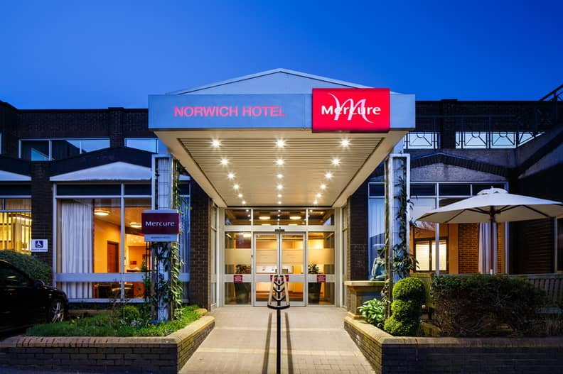 Illuminated exterior entrance of the Mercure Norwich Hotel at dusk with canopy lighting.