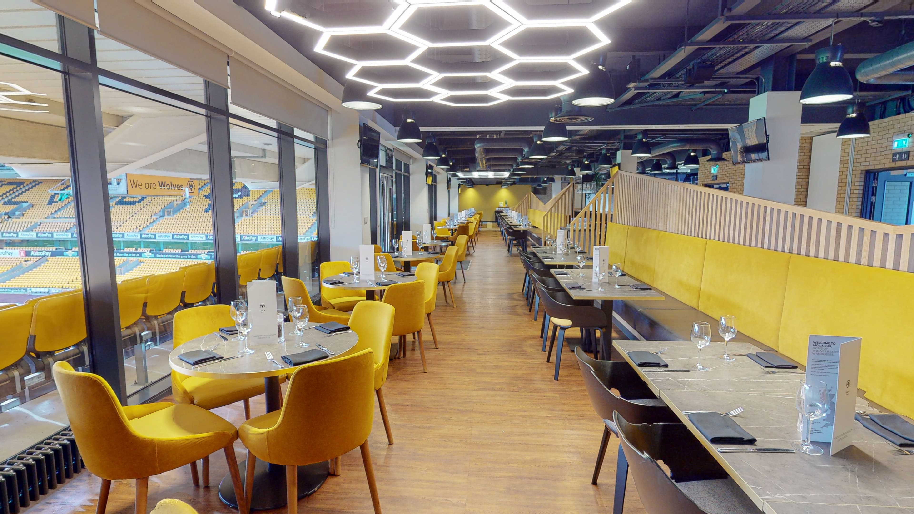 Hospitality dining room with yellow chairs and views over the Molineux pitch