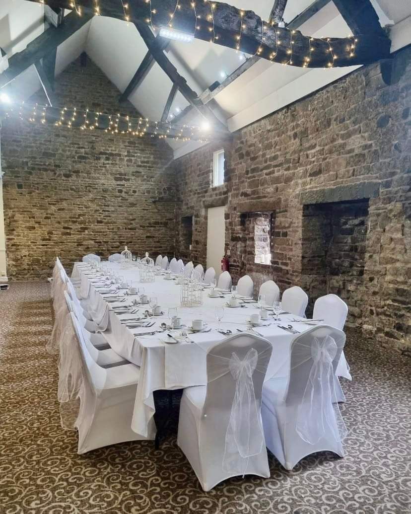 Stone-walled Haddon Suite at Mosborough Hall Hotel with long white-dressed banquet table