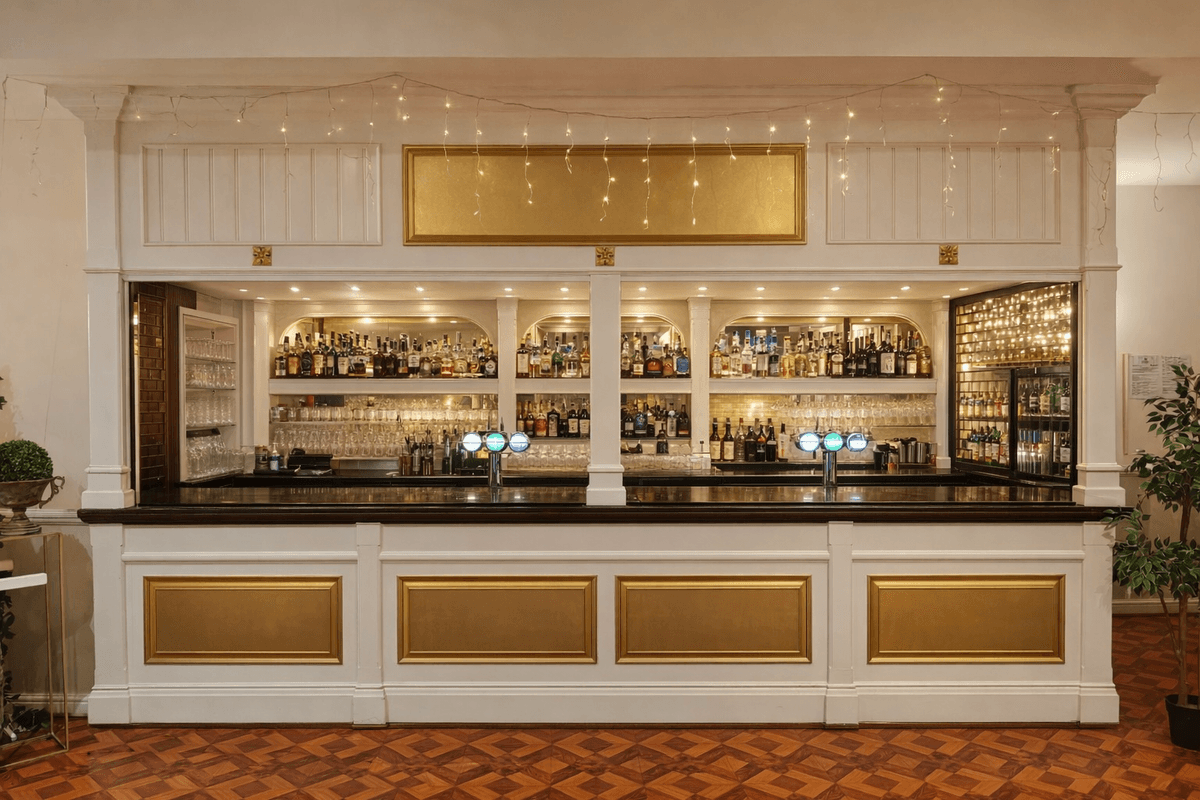 White and gold bar with draped fairy lights, spirit shelves and draught taps.