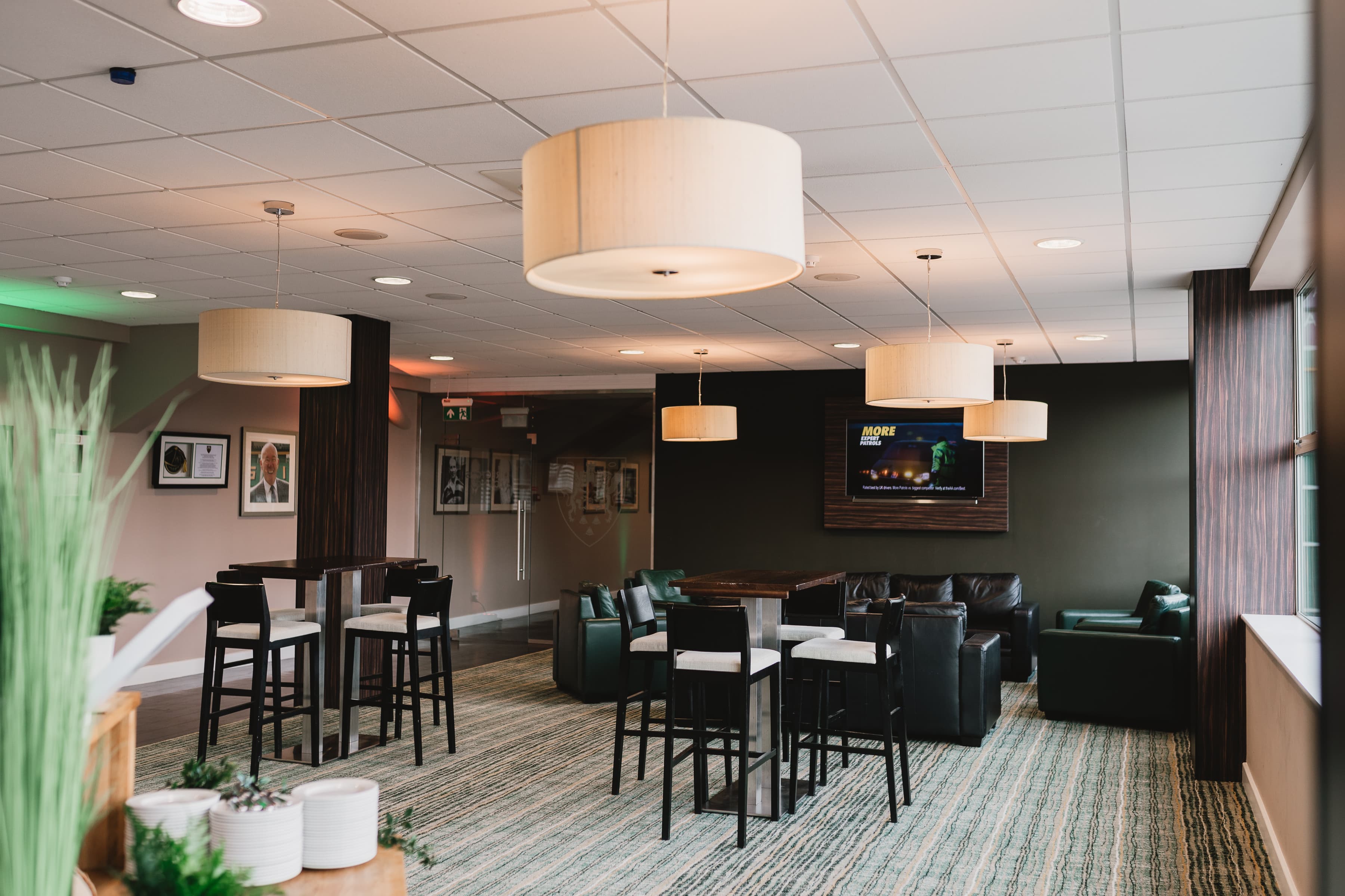 Hospitality lounge with tall bar tables, leather sofas and pendant lighting at Franklin's Gardens.