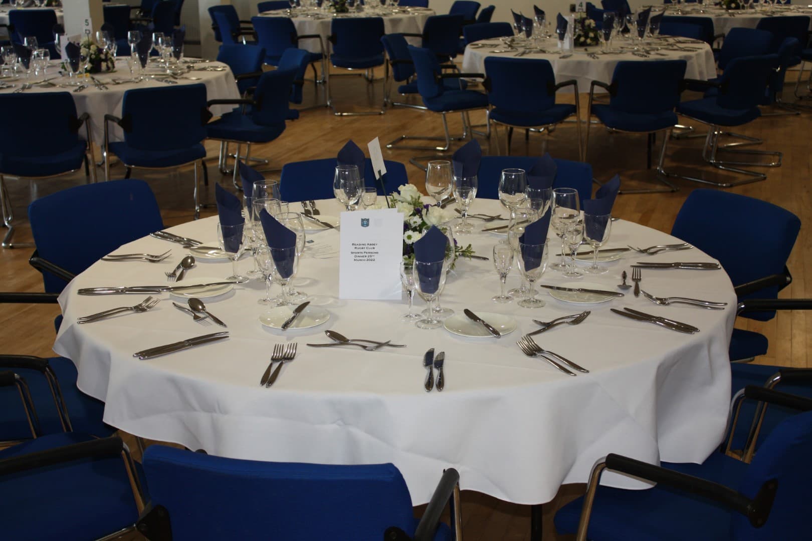 Banqueting room at Reading Abbey RFC laid for a formal dinner with round tables.