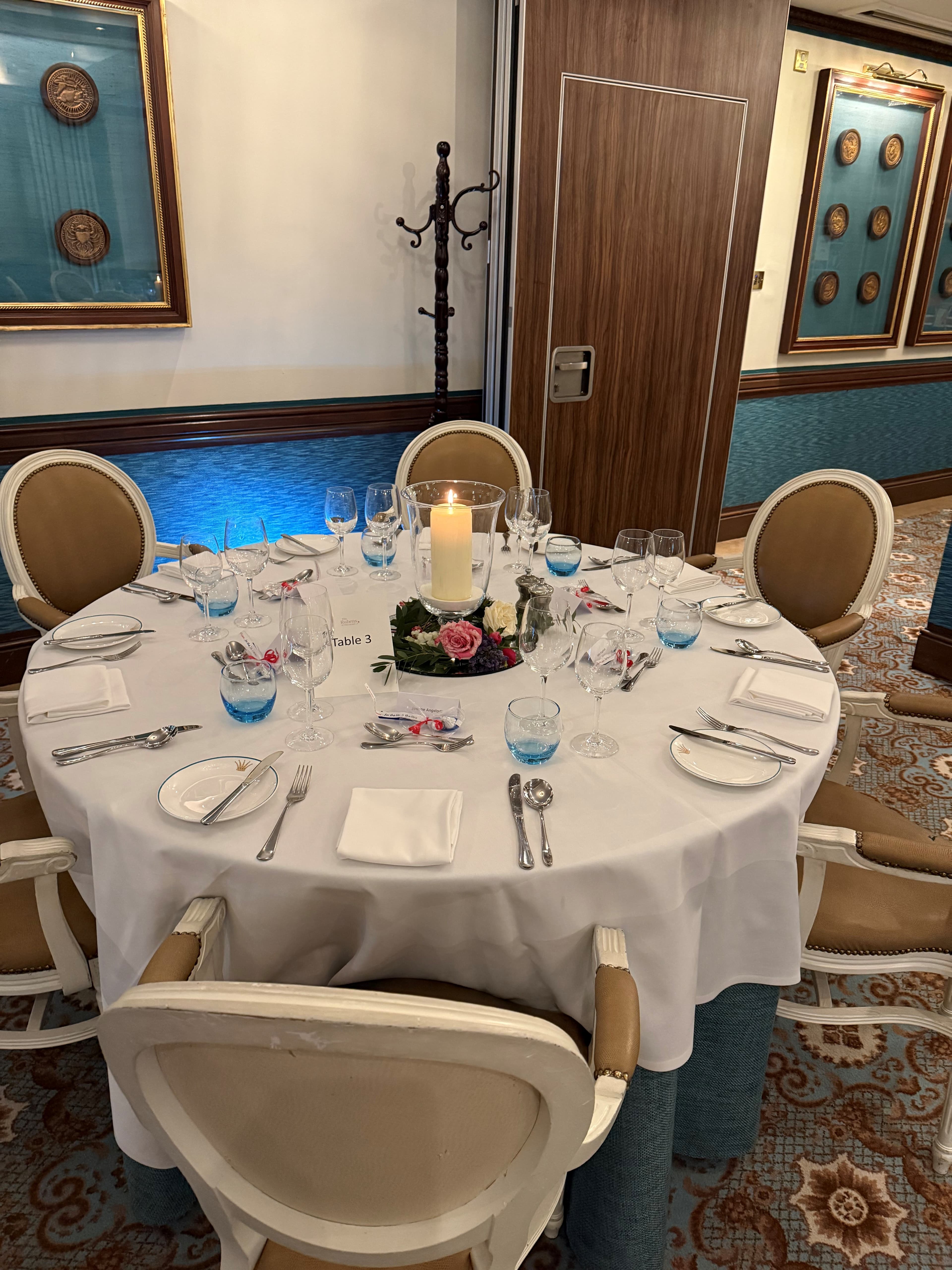 Round dining table set for eight with candle centrepiece in a private room at Rubens at the Palace.