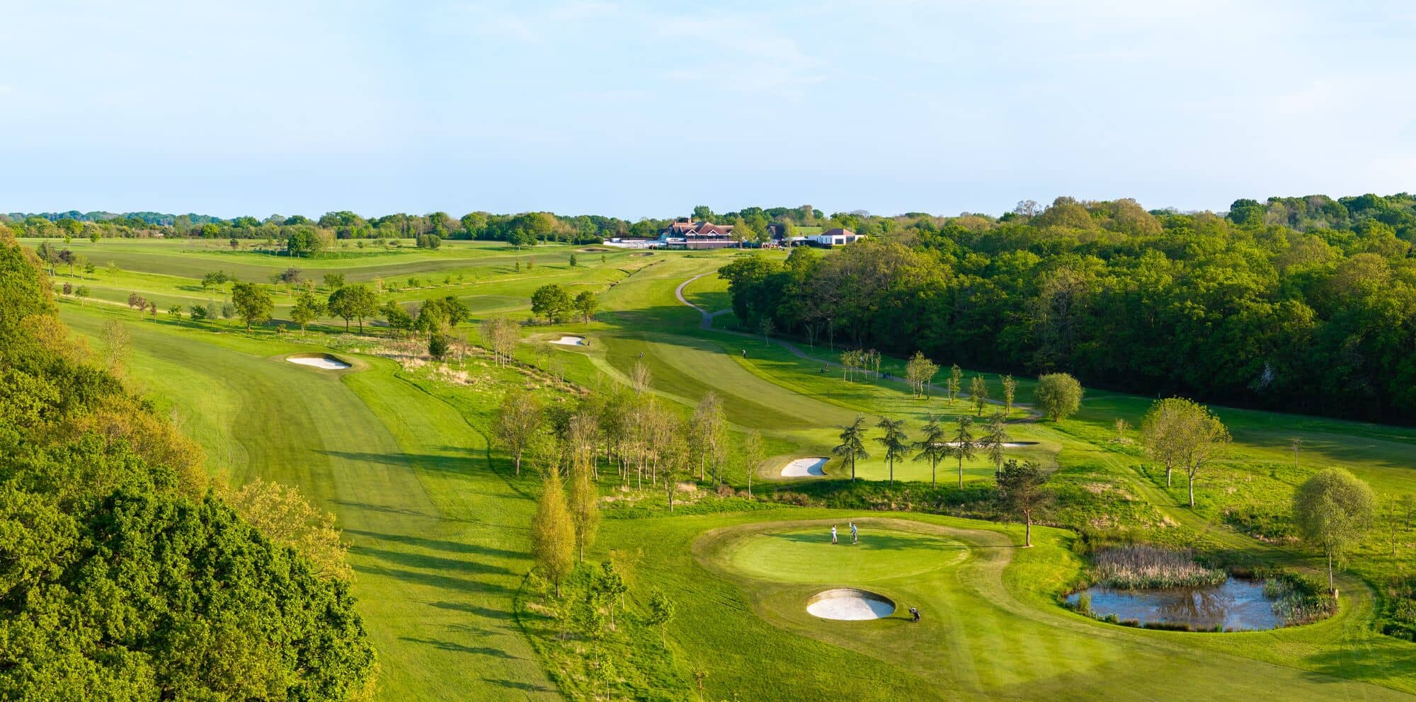 Aerial view of Skylark Country Club golf course with bunkers, pond and clubhouse beyond.