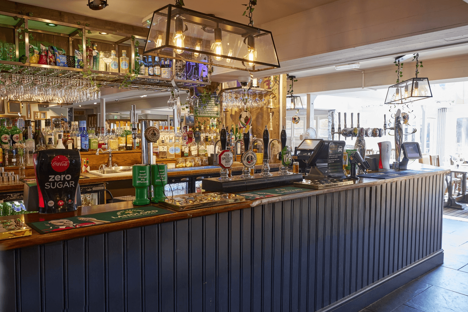 The bar at St Leonards Hotel showing ale taps, spirits and hanging glassware.