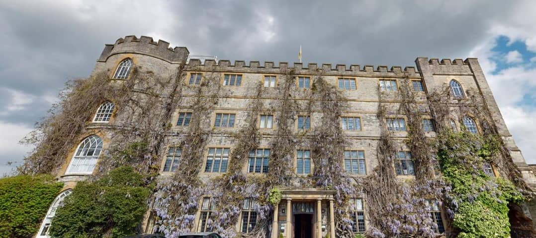 Exterior of The Castle Hotel Taunton with wisteria growing across the stone facade.