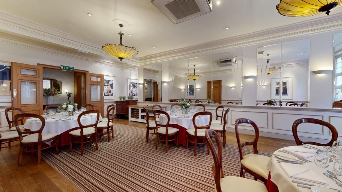 Private dining room with round tables, balloon-back chairs and striped carpet at The Castle Hotel Taunton.
