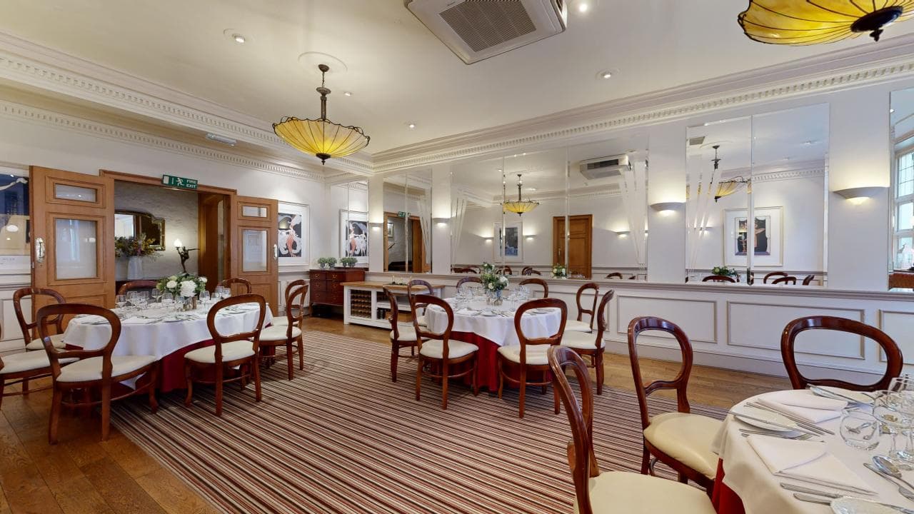 Private dining room with round tables, balloon-back chairs and striped carpet at The Castle Hotel Taunton.