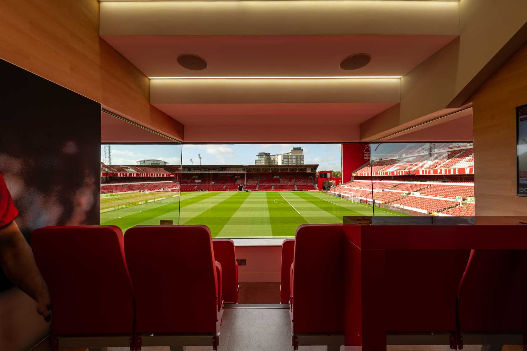Private box interior with red seating and panoramic views over the pitch at The City Ground.