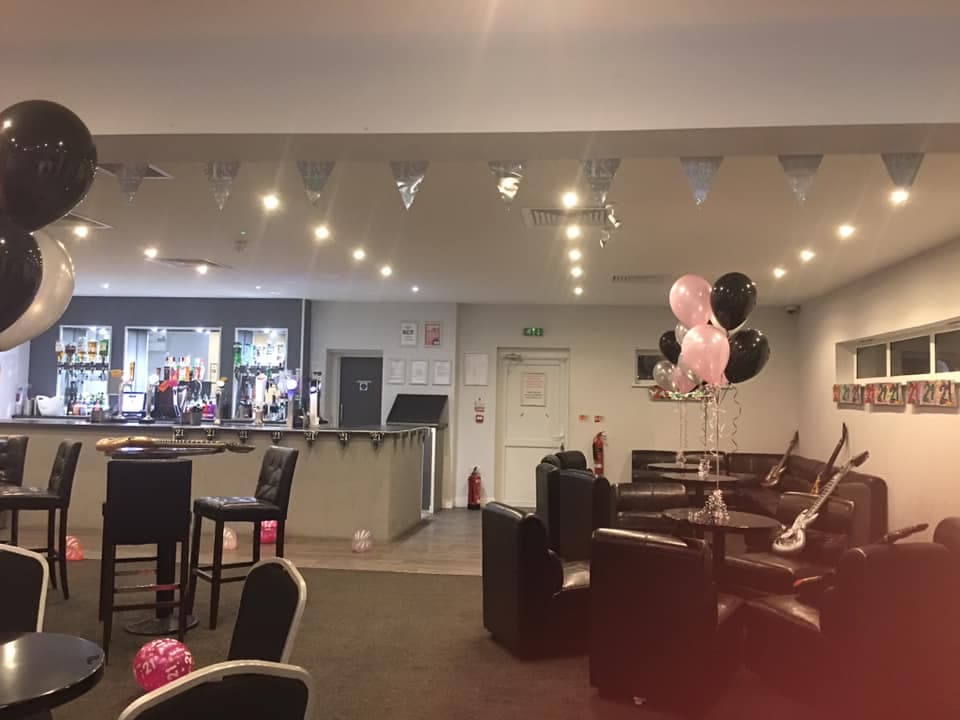 Function room decorated with black and pink balloons and silver bunting for a 21st birthday.