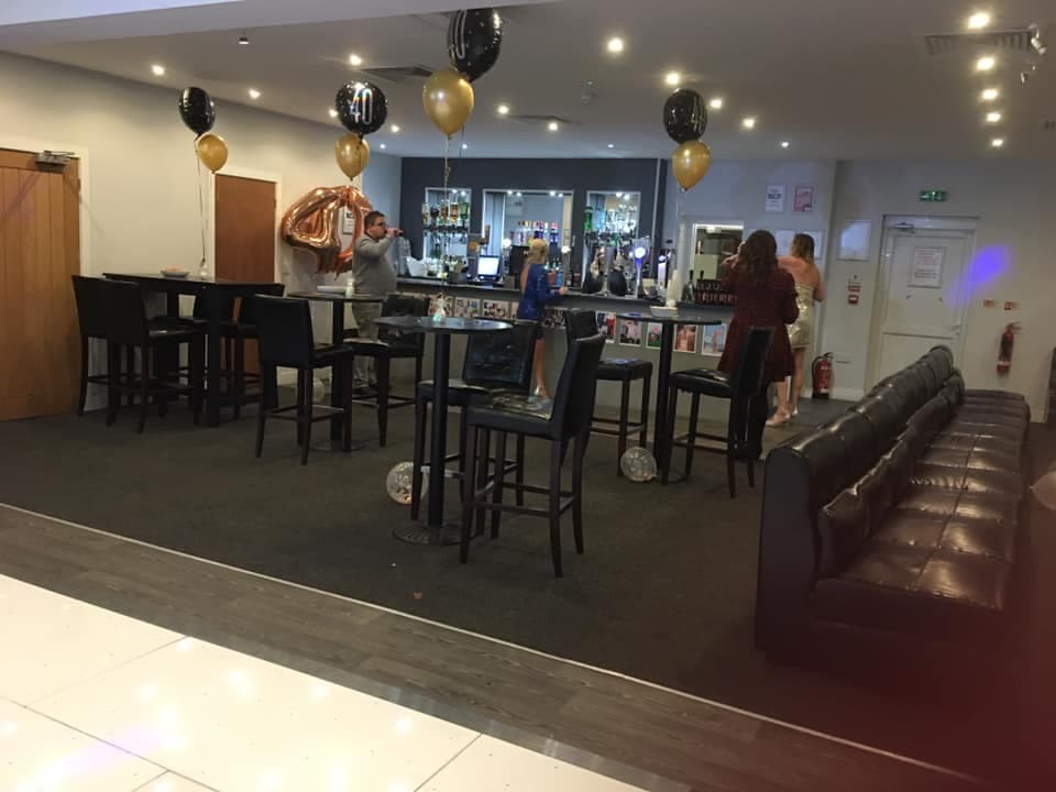 Bar area decorated with black and gold balloons for a 40th birthday party.