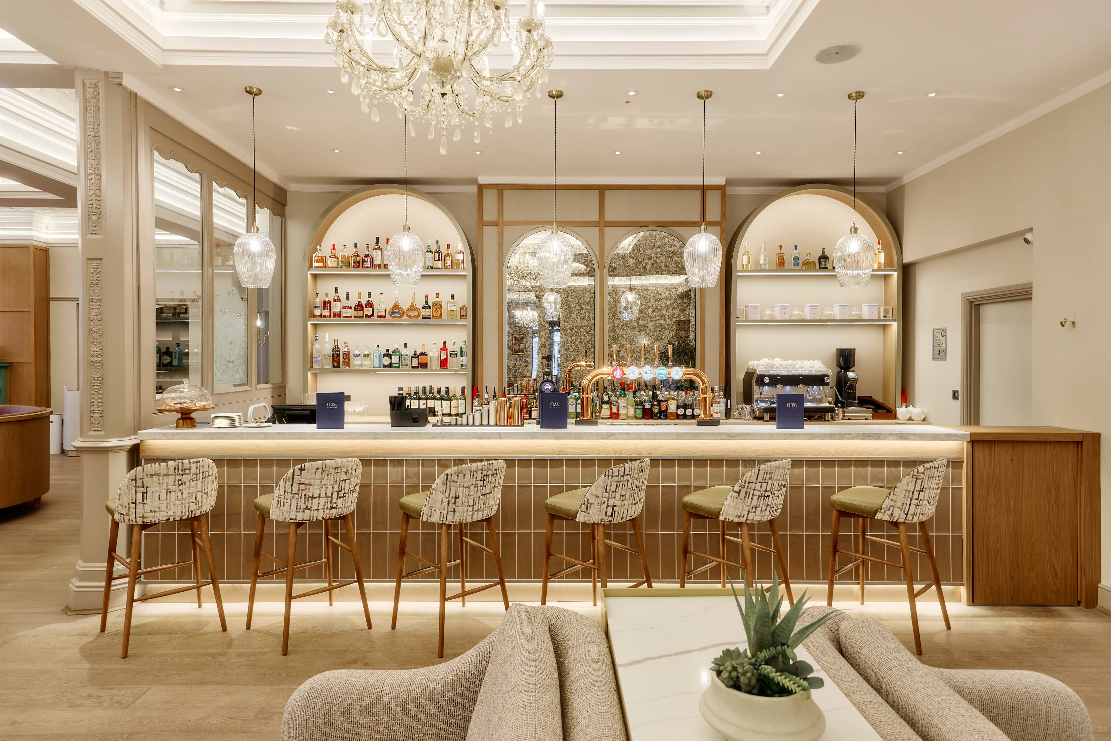 The Grand Hotel Leicester bar with marble counter, bar stools and arched back shelving.