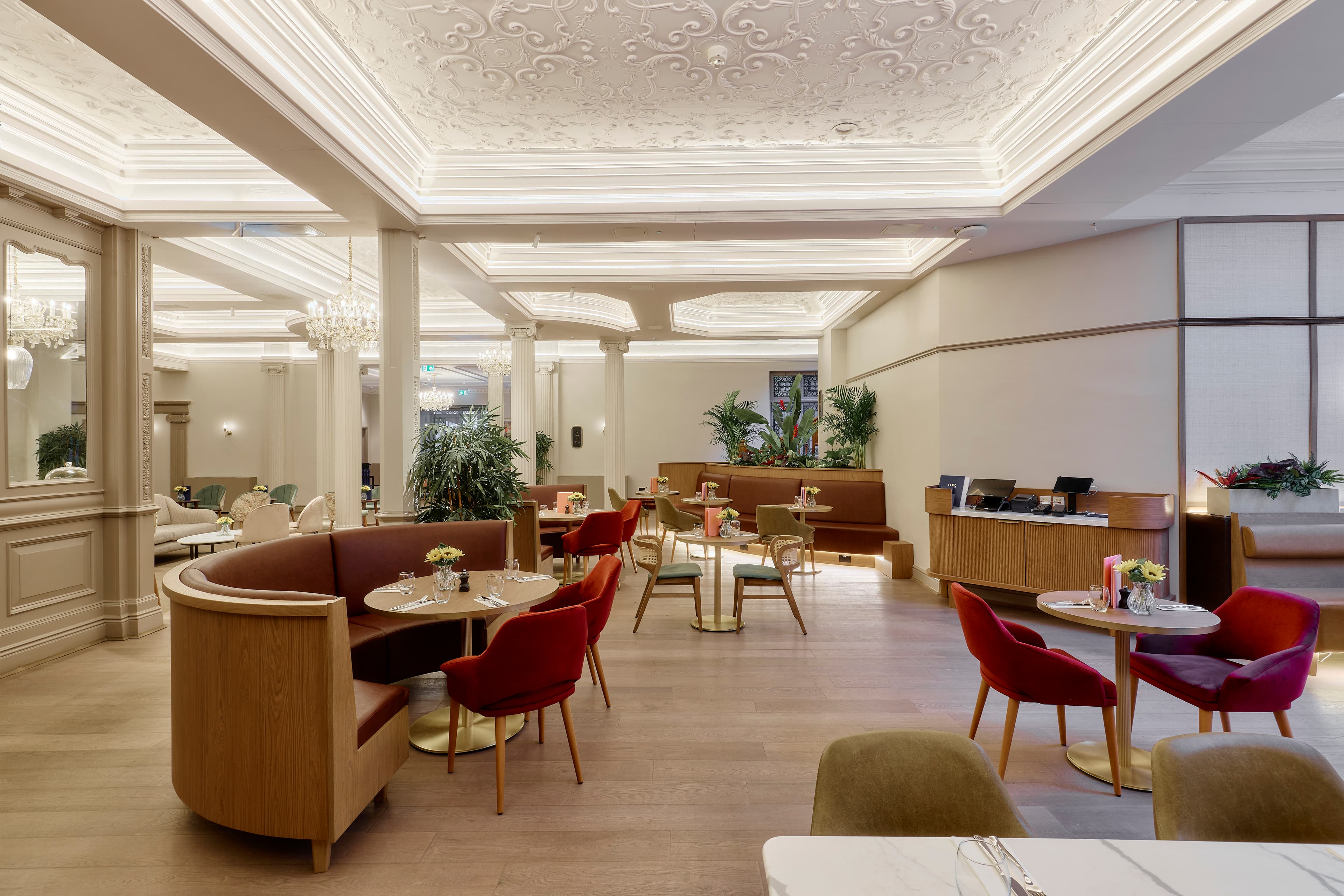 Grand Hotel Leicester restaurant interior with ornate plasterwork ceiling, booths and red armchairs.