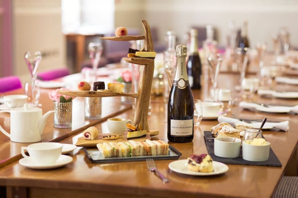 Afternoon tea spread with Louis Roederer champagne, sandwiches and cakes at The Green House Hotel.