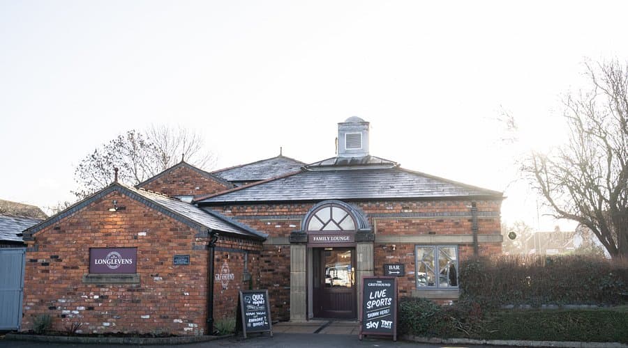 Exterior of The Greyhound pub in Gloucester, a red brick building with slate roof.