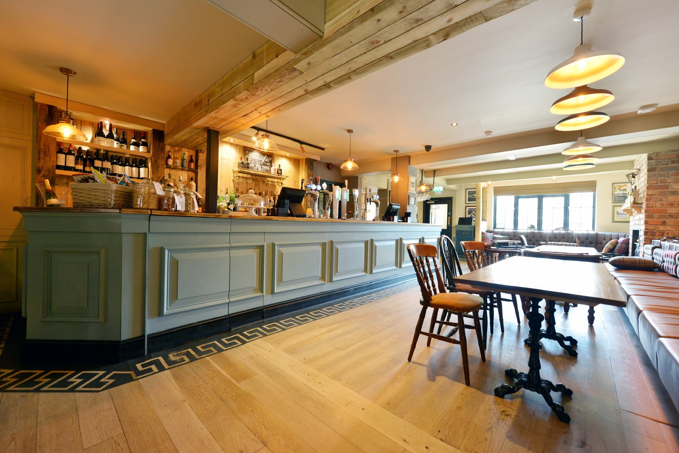 The bar area at The Railway pub in Nottingham with wooden flooring and beer taps.