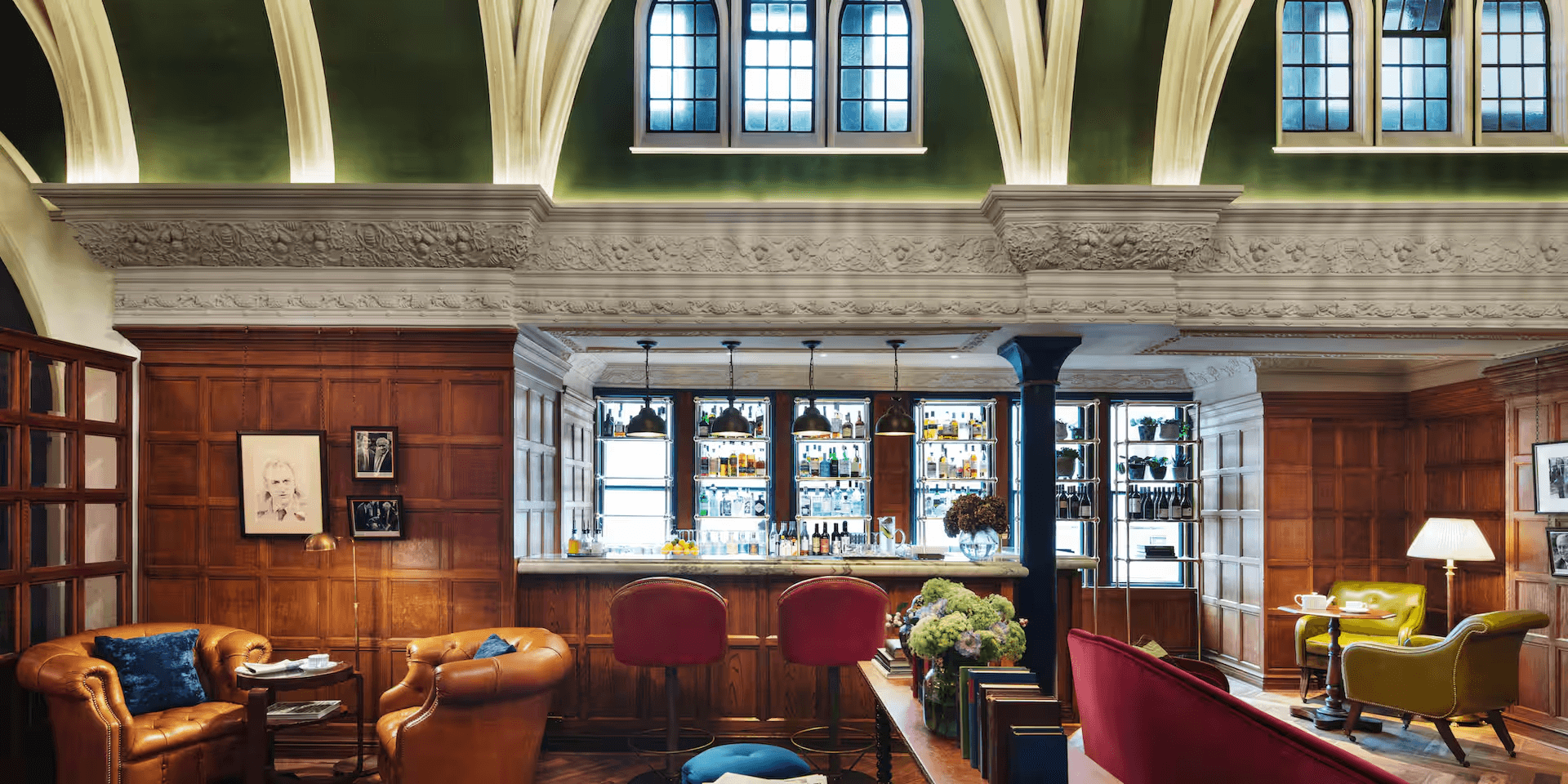 The Randolph Hotel bar with oak panelling, leather armchairs and vaulted ceiling above.