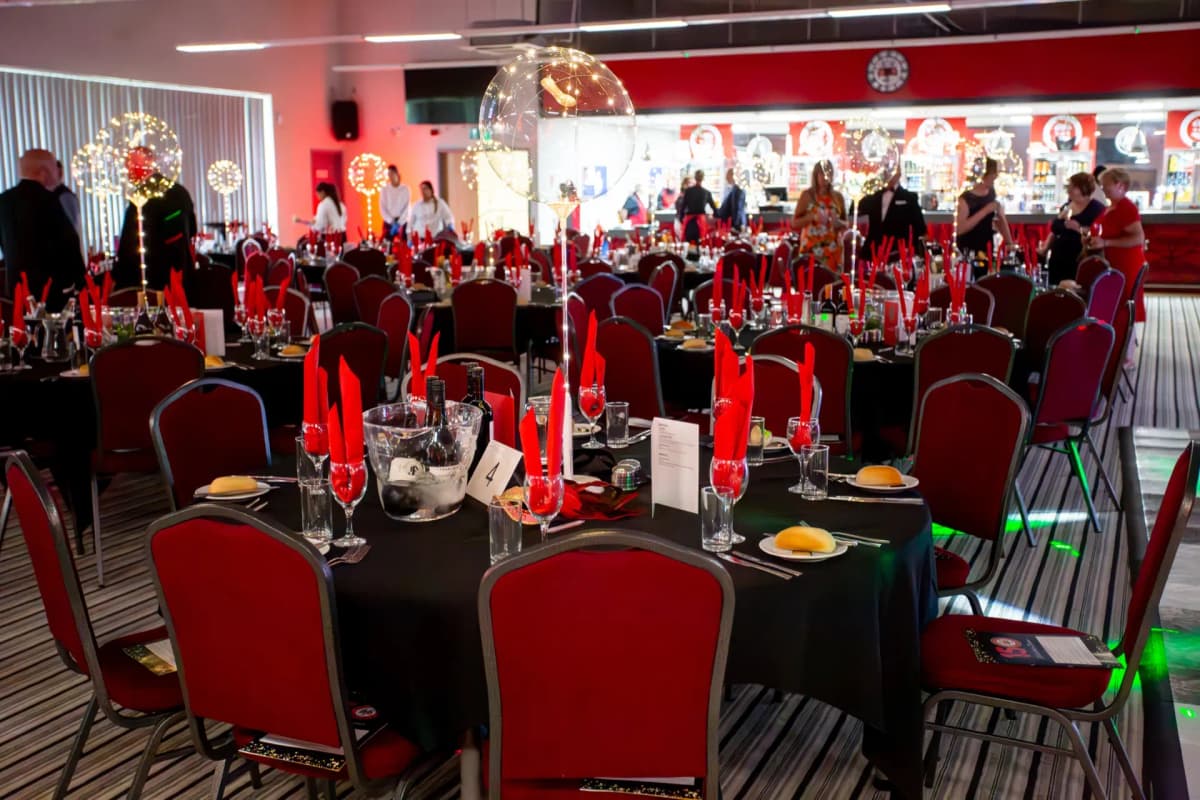 The Reddings Suite function room set for a gala dinner with red and black décor.