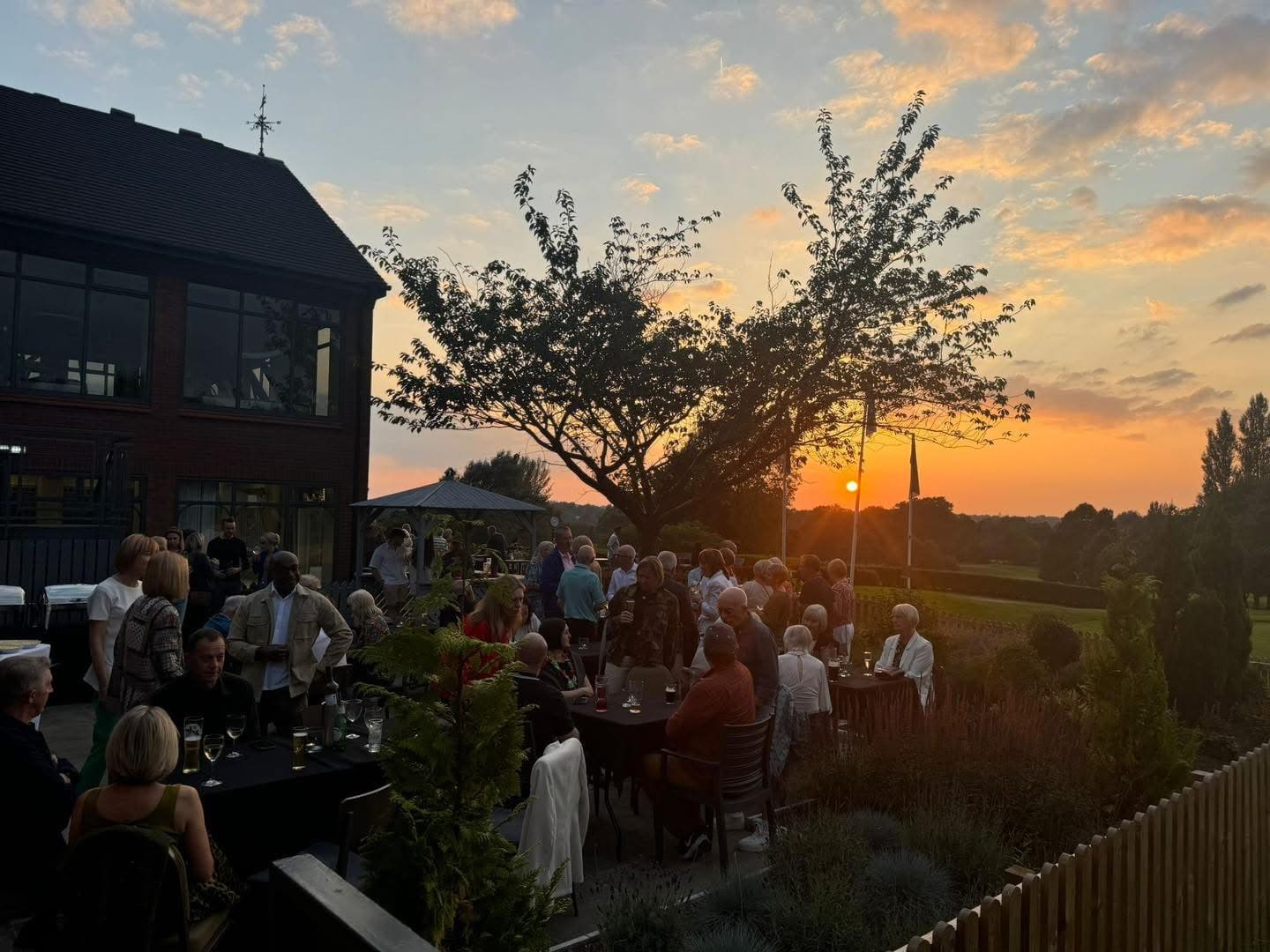 Guests gathered on the terrace at sunset beside the Tytherington Club building.