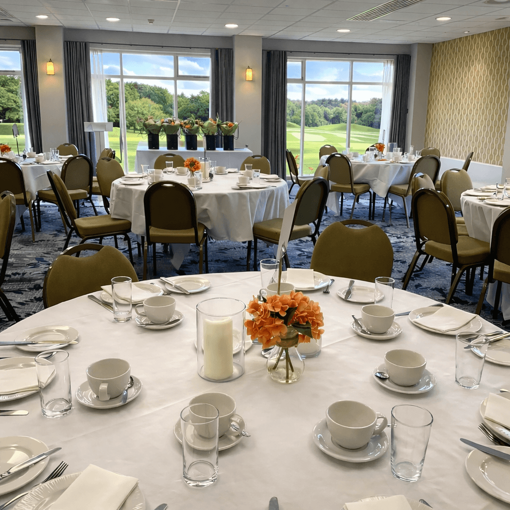 Tytherington Club function room with round tables set for dining overlooking a golf course.
